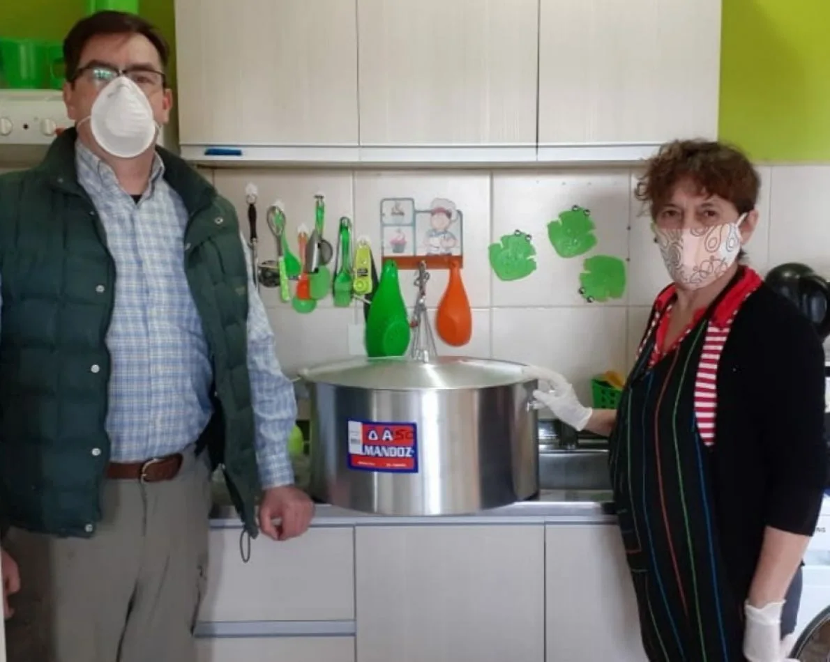 Integrante del Rotary Club Río Grande entrega un cacerola al Comedor de María.