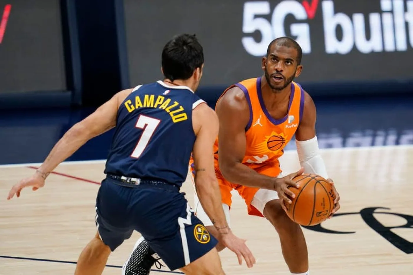 El jugador de los Suns de Phoenix Chris Paul (derecha) se prepara para un lanzamiento ante su rival de los Nuggets de Denver Facundo Campazzo.