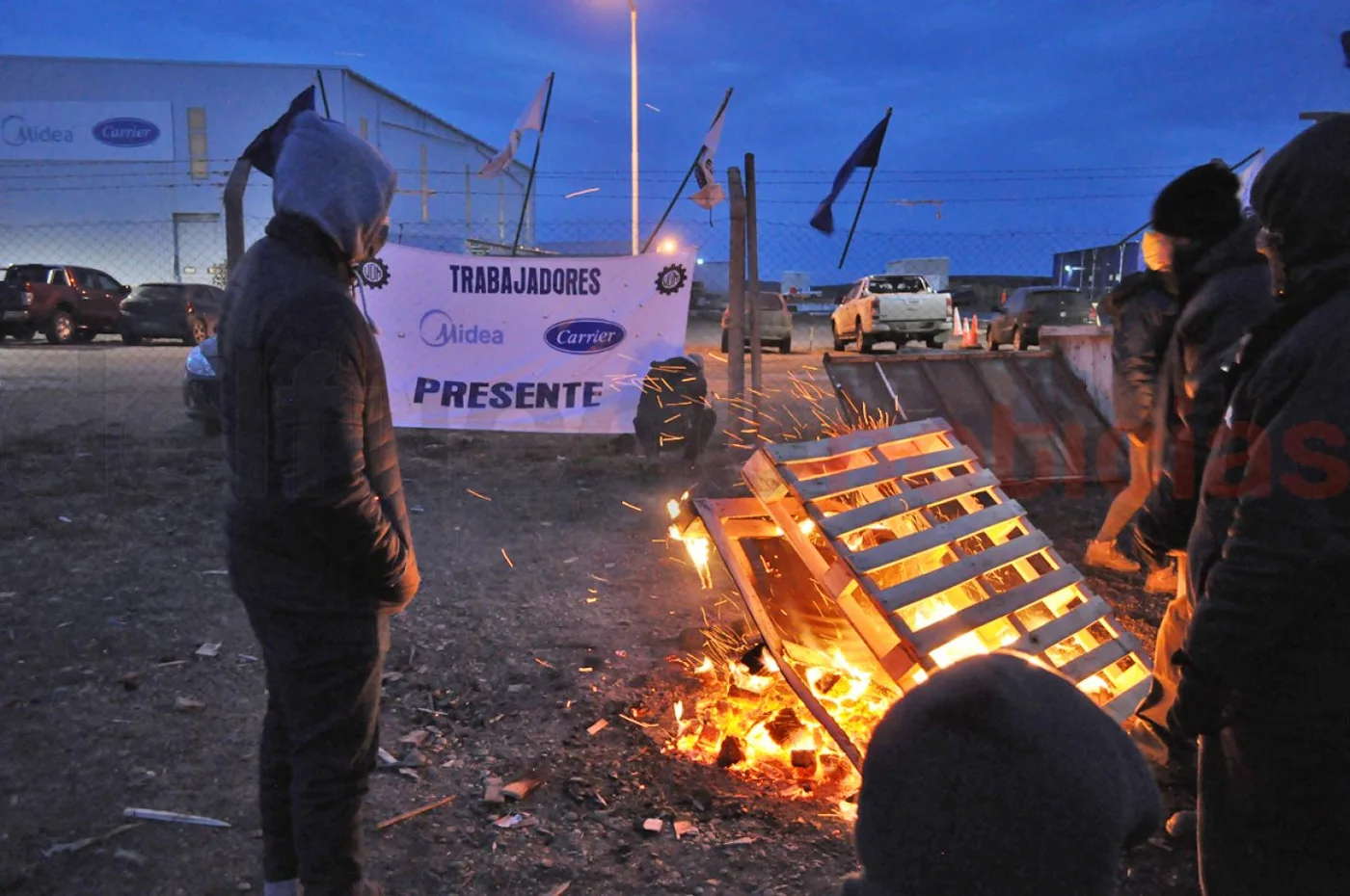 Los trabajadores se mantienen en la puerta de la planta fabril.