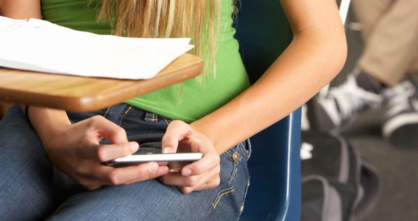 Estudiante usando el celular en la escuela