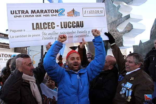 Federico Sciurano celebra a la llegada. Detras de él, el cheque simbólico con lo recaudado.